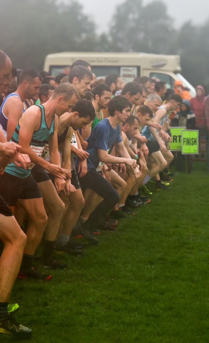 Fell racers on the start line at Grasmere Sports 2024, in soggy and wet conditions.