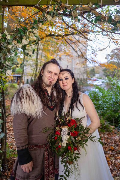 Benjamin and Annmarie Coomber, with a backdrop of Langley Castle, on the day of their Viking wedding.