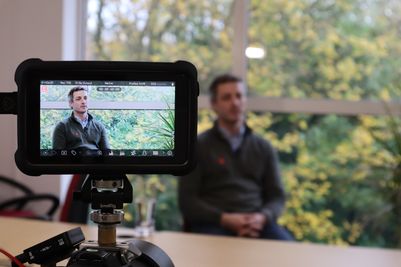 TEAM-Energy-Commercial-director-Tom-Anderton-interviewed-visible-in-viewfinder-sat-in-front-of-a-window-with-greenery.JPG