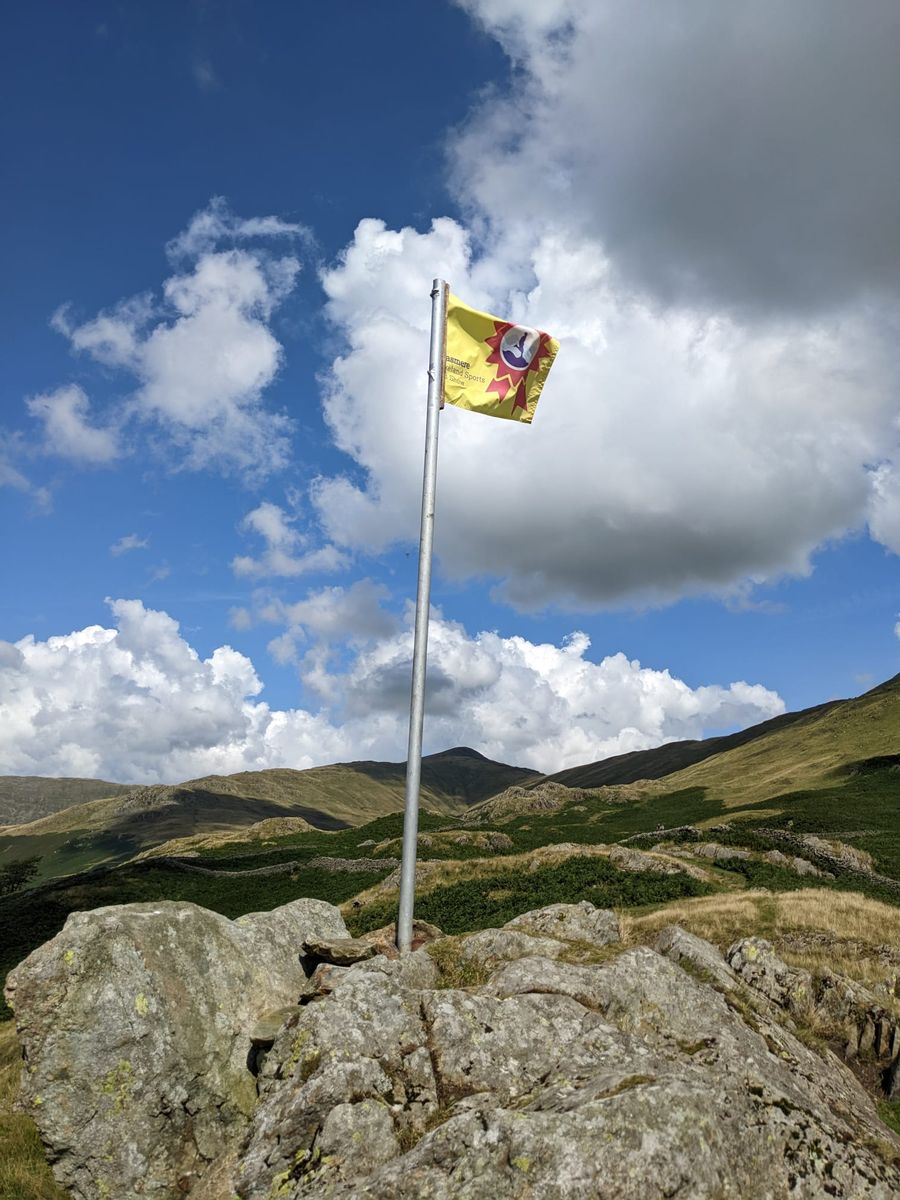 Grasmere Lakeland Sports and Show flag flying at the top of the fell, acting as a guide for the fell runners heading to the top.