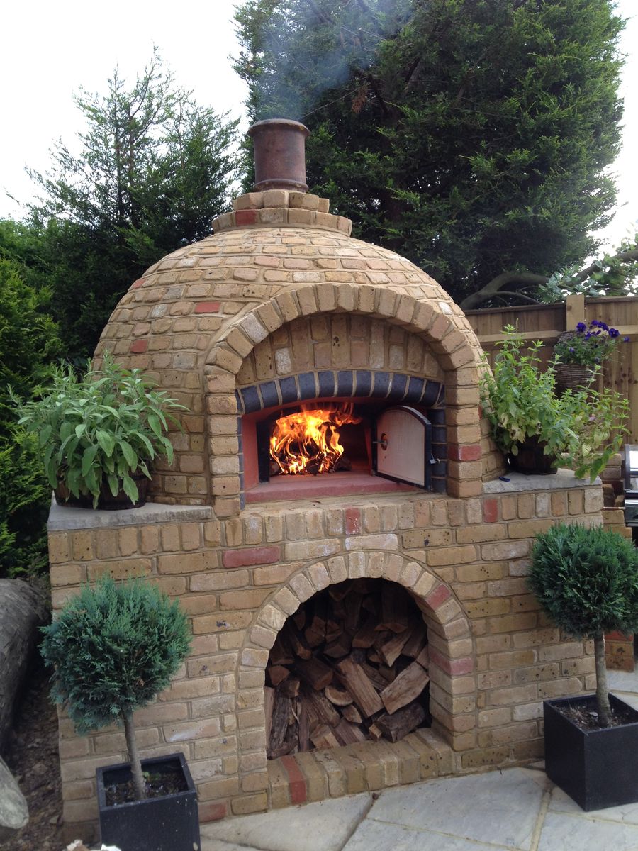 Fire burning in a Valoriani wood-fired pizza oven, created in a bespoke brick surround with the assistance of UK supplier, Orchard Ovens