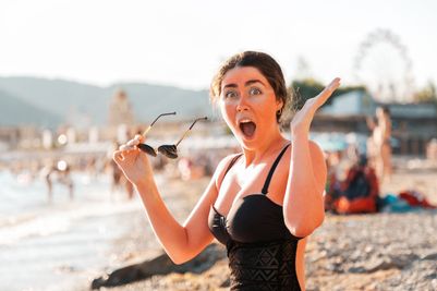 Woman suffering shock of discovering she's incurred serious sunburn whilst on the beach.
