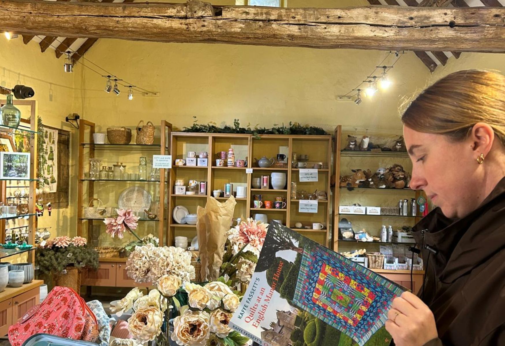 Person browsing Kaffe Fassett's 2026 book in Levens Hall and Gardens gift shop
