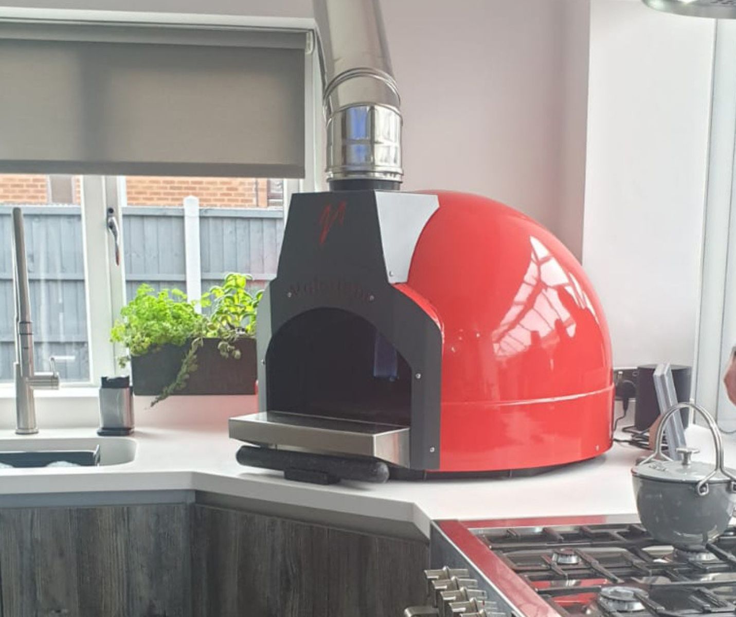Cucina - the indoor version of the Fornino 60 oven - in an indoor kitchen setting and in one of the standard colours of red.