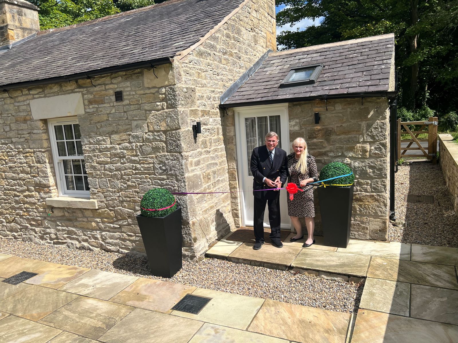 Dr Stuart and Dr Mariann Madnick, Baron and Baroness of Langley, perform the ribbon cutting at Toll Bar Luxury Villa, at Langley Castle, Northumberland, UK