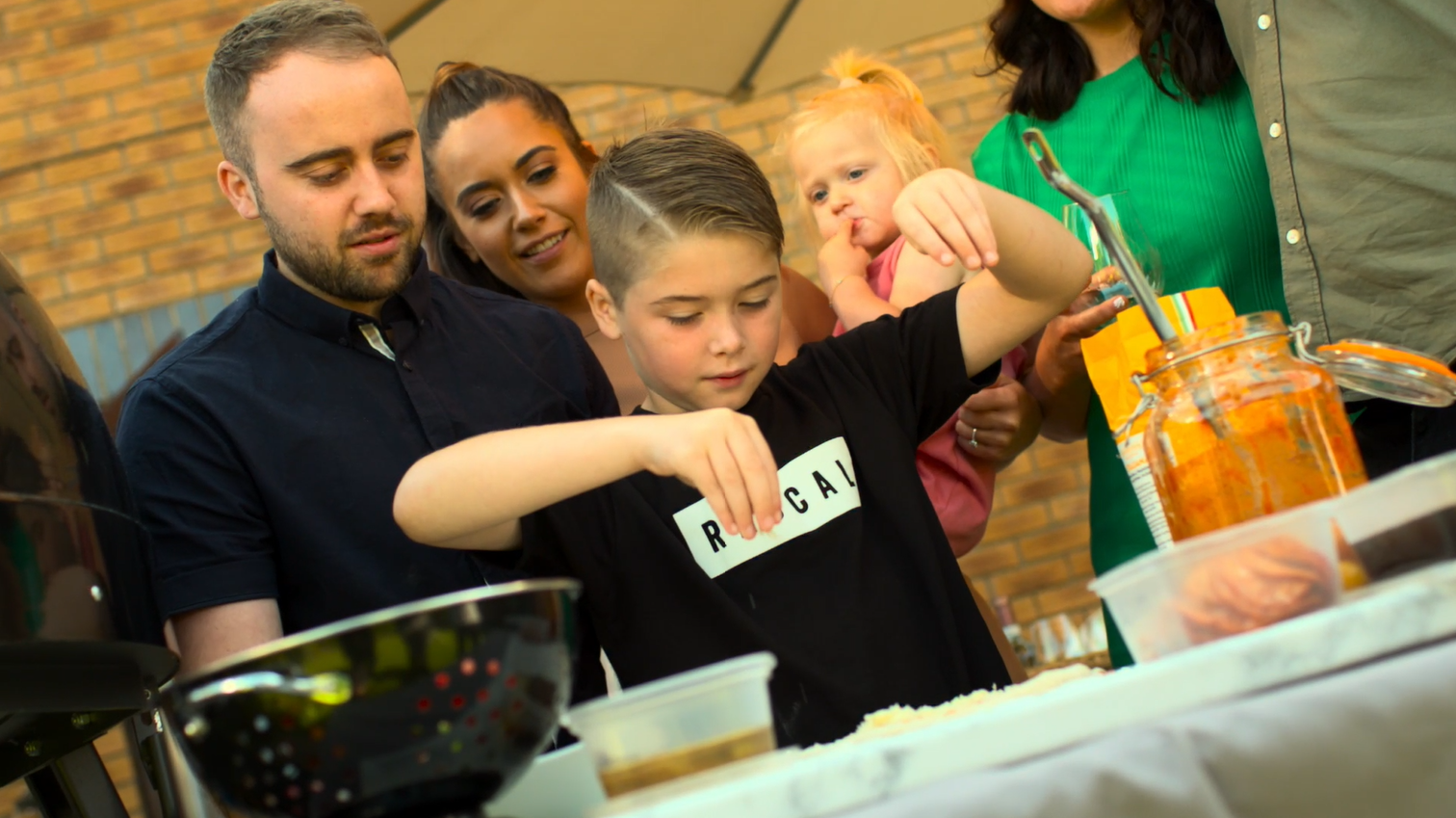 Families bonding over pizza making in a UK garden and with an Orchard Ovens supplied Valoriani pizza oven