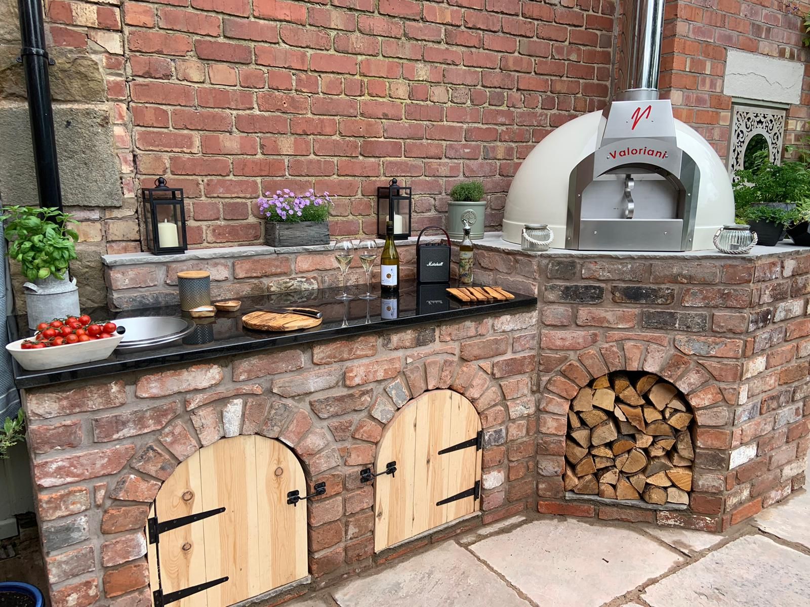 Cream-finish Fornino 75 oven incorporated into an outdoor kitchen design built in brick.