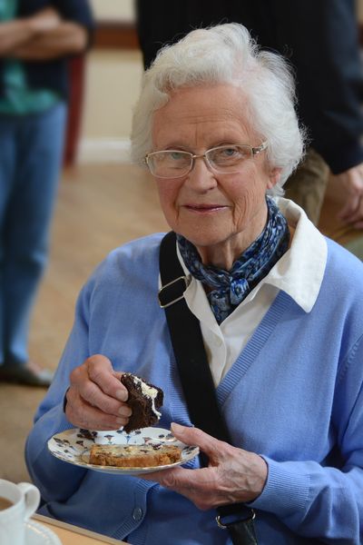 Elderly vegetarian lady eating cake