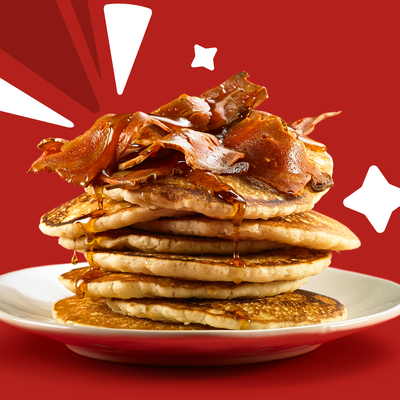 Fluffy American Style Pancakes topped with maple syrup and vegan bacon