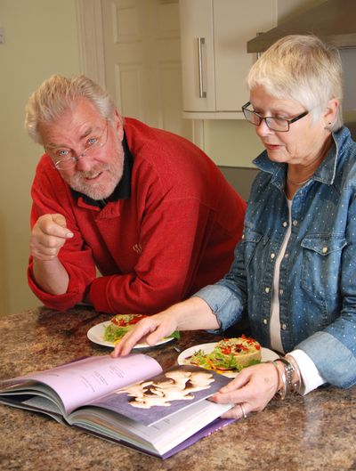 Vegetarian couple looking through a cook book