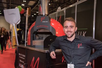Dino Manciocchi of Valoriani UK, with a red Fornino 60 baby pizza oven
