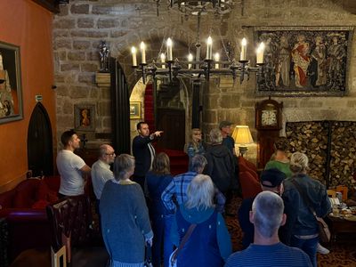 Langley Castle hotel guests enjoying the daily Battlements Tour at its start, in the atmospheric Drawing Room.