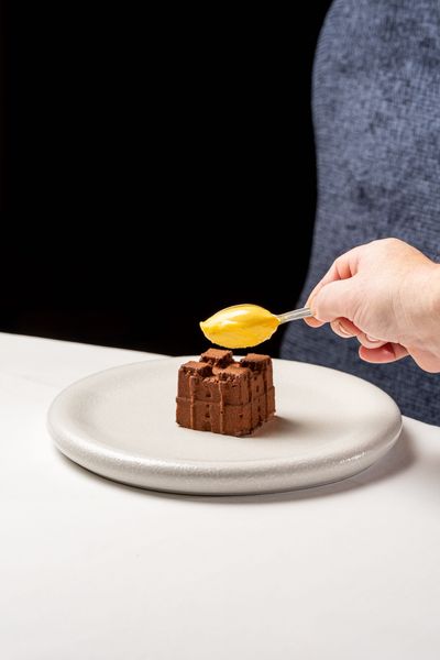 Sorbet being applied to the Dark Chocolate Castle dessert, created as a replica of medieval Langley Castle Hotel, Northumberland, UK, in chocolate mousse.  The dish is the creation of Langley Castle's Culinary Director, Mark Greenaway.
