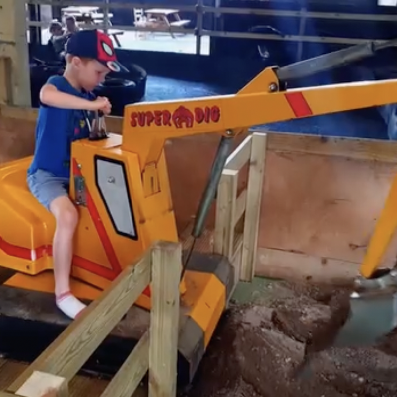 Child on digger at the Lakeland Maze Farm Park in Sedgwick near Kendal