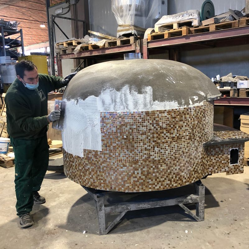 A pizza oven being hand decorated in the Valoriani factory in Tuscany