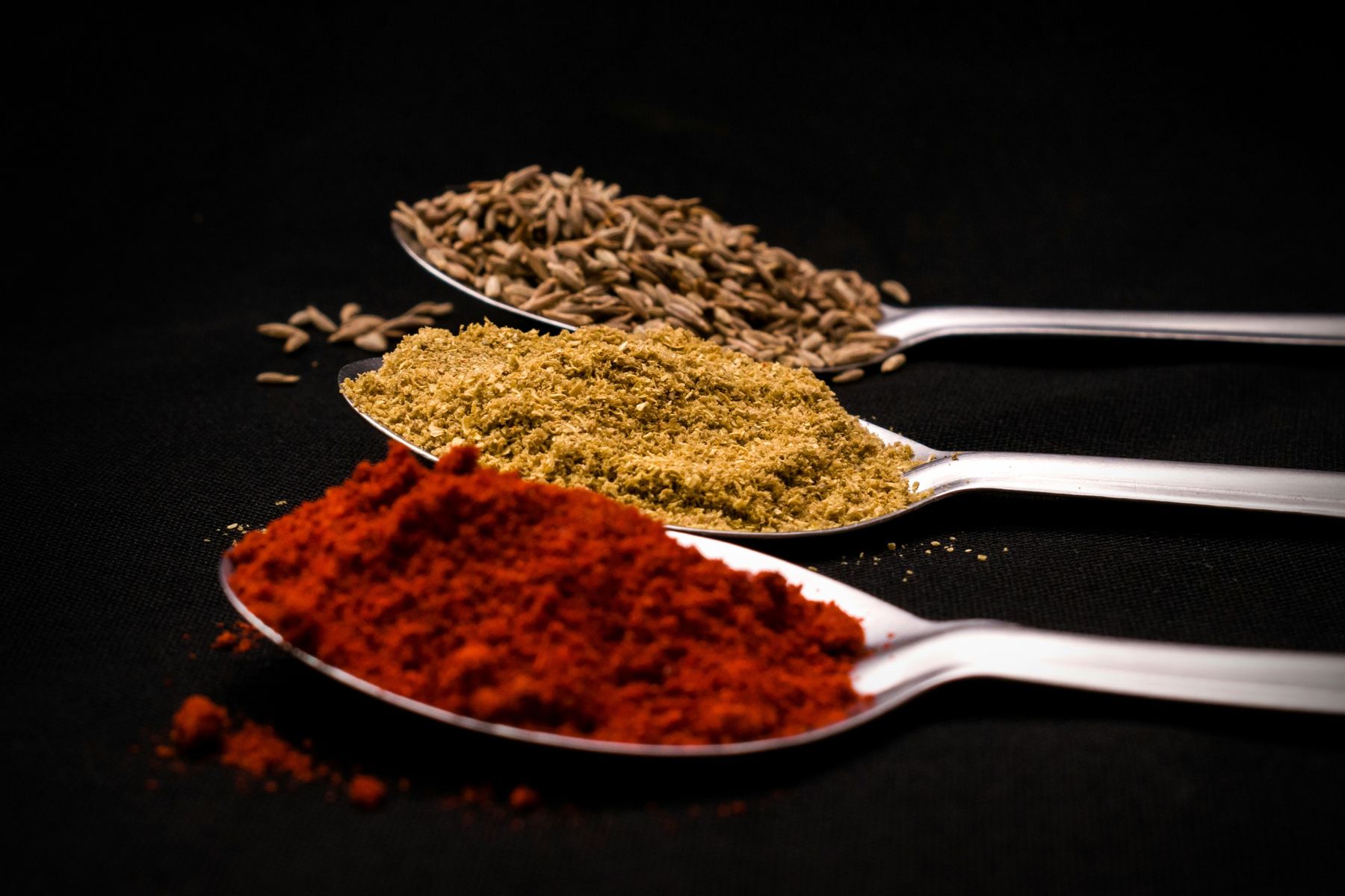 Array of spices on spoons, which could easily be used in dishes cooked in an Orchard Ovens-supplied Valoriani oven in the UK.