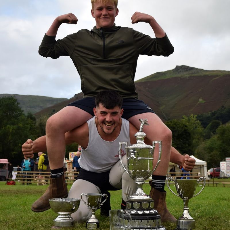 Thomas Gibson All Weights World Champion 2023 in Cumberland and Westmorland wrestling, in a contest won at Grasmere Lakeland Sports and Show, lifts one of the new 'names' in the sport, George Peacock.