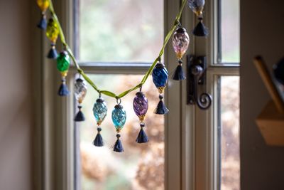 Assorted coloured baubles with grey tassels on green ribbon 1.jpg