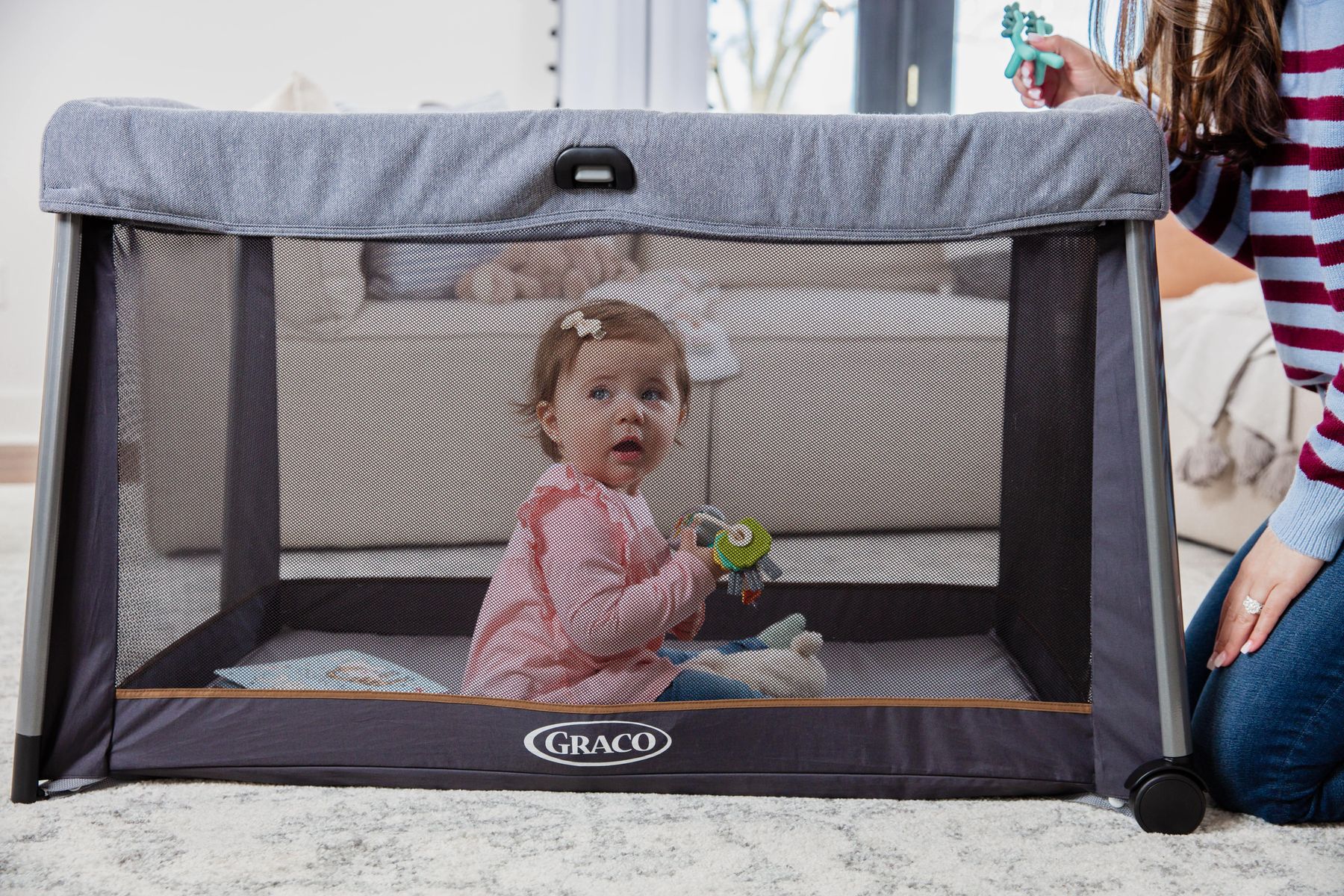 Graco FoldLite Travel Cot pictured with child playing in the cot 