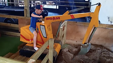 Child on digger at the Lakeland Maze Farm Park in Sedgwick near Kendal