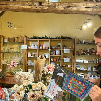 Person browsing Kaffe Fassett's 2026 book in Levens Hall and Gardens gift shop