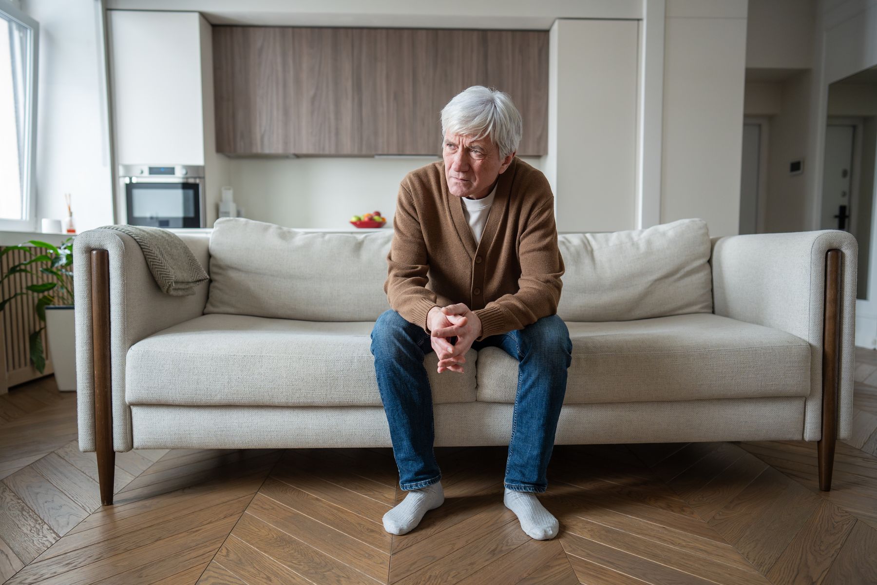 Lonely senior man sitting at home with emotional distress