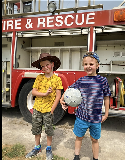 Two children play firefighter at the Lakeland Maze Farm Park