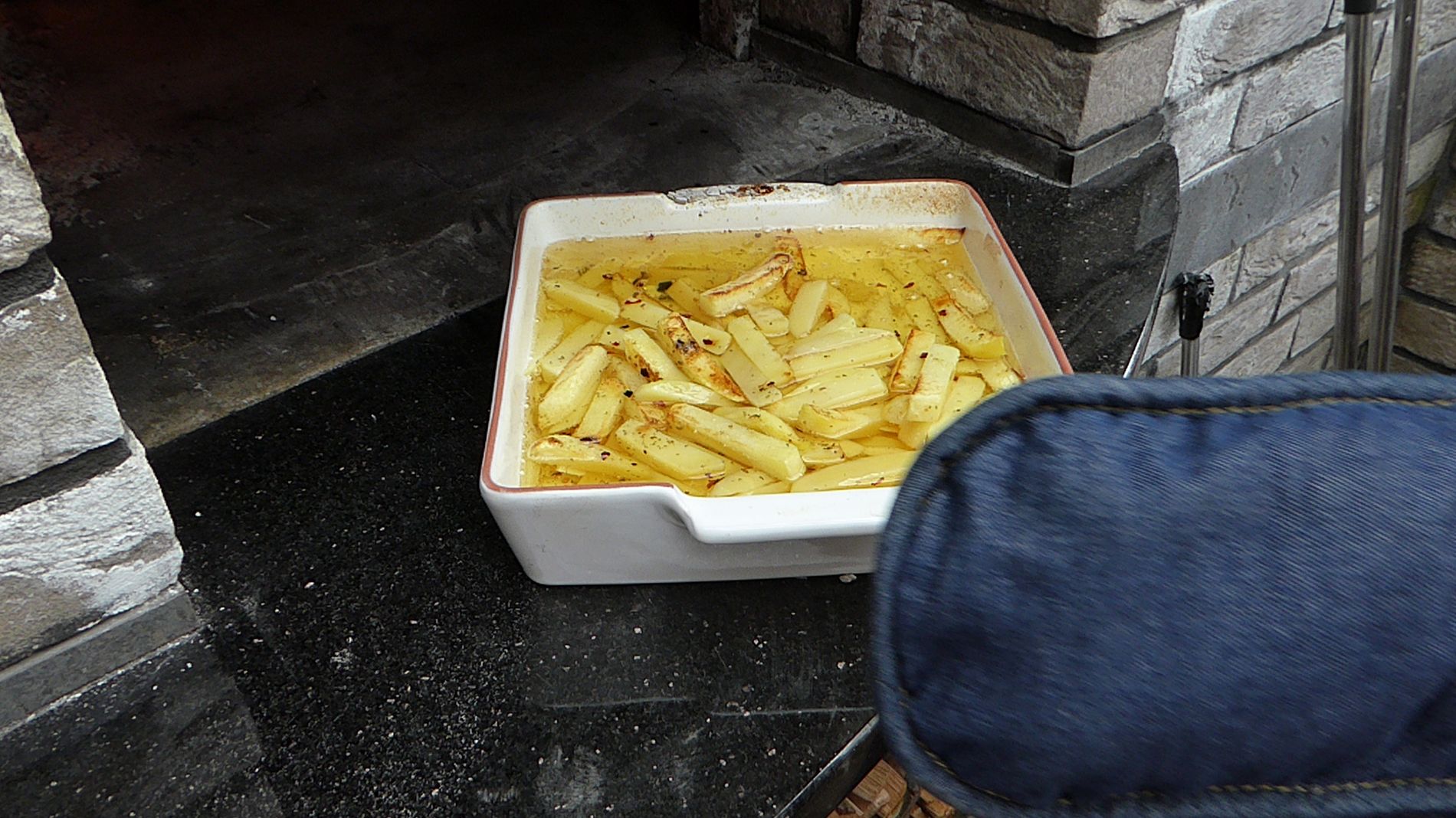 Raw chips, about to enter the oven mouth for gentle and continuously observed cooking in a Valoriani wood-fired oven 
