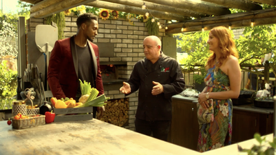 Andrew Manciocchi (centre) talks to two clients in an outdoor kitchen created by Orchard Ovens