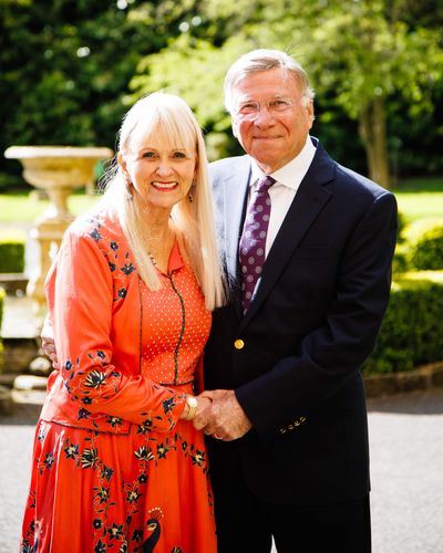 Baron and Baroness of Langley, Dr Stuart and Dr Mariann Madnick, by the fountain outside the medieval castle that Dr Stuart turned into a hotel and restaurant in 1986.