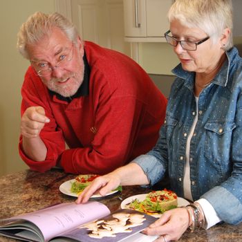 Vegetarian couple looking through a cook book