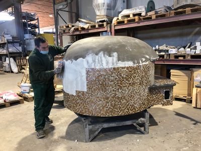 A pizza oven being hand decorated in the Valoriani factory in Tuscany