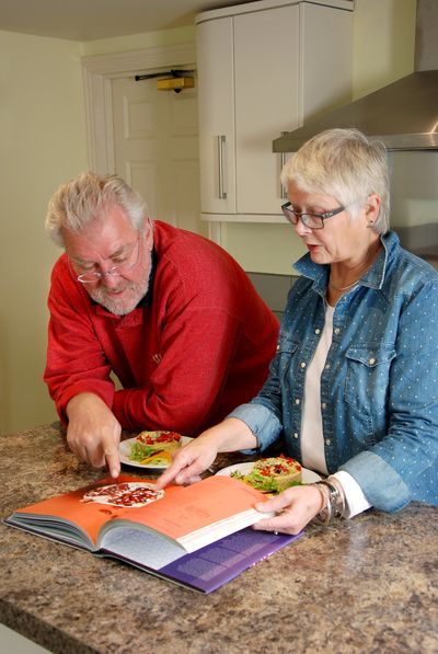 Vegetarian couple chatting about a recipe in a book