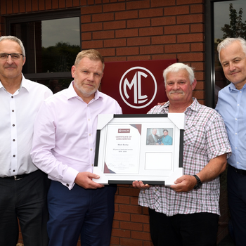 Mark Busby stood with McPhillips directors and presented with a framed certificate.jpg