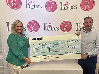 Glazerite's Jeff Dunn presents Sherry Adams, CEO of Kelly's Heroes with the money raised from Glazerite's 17th Pro Am Golf Day