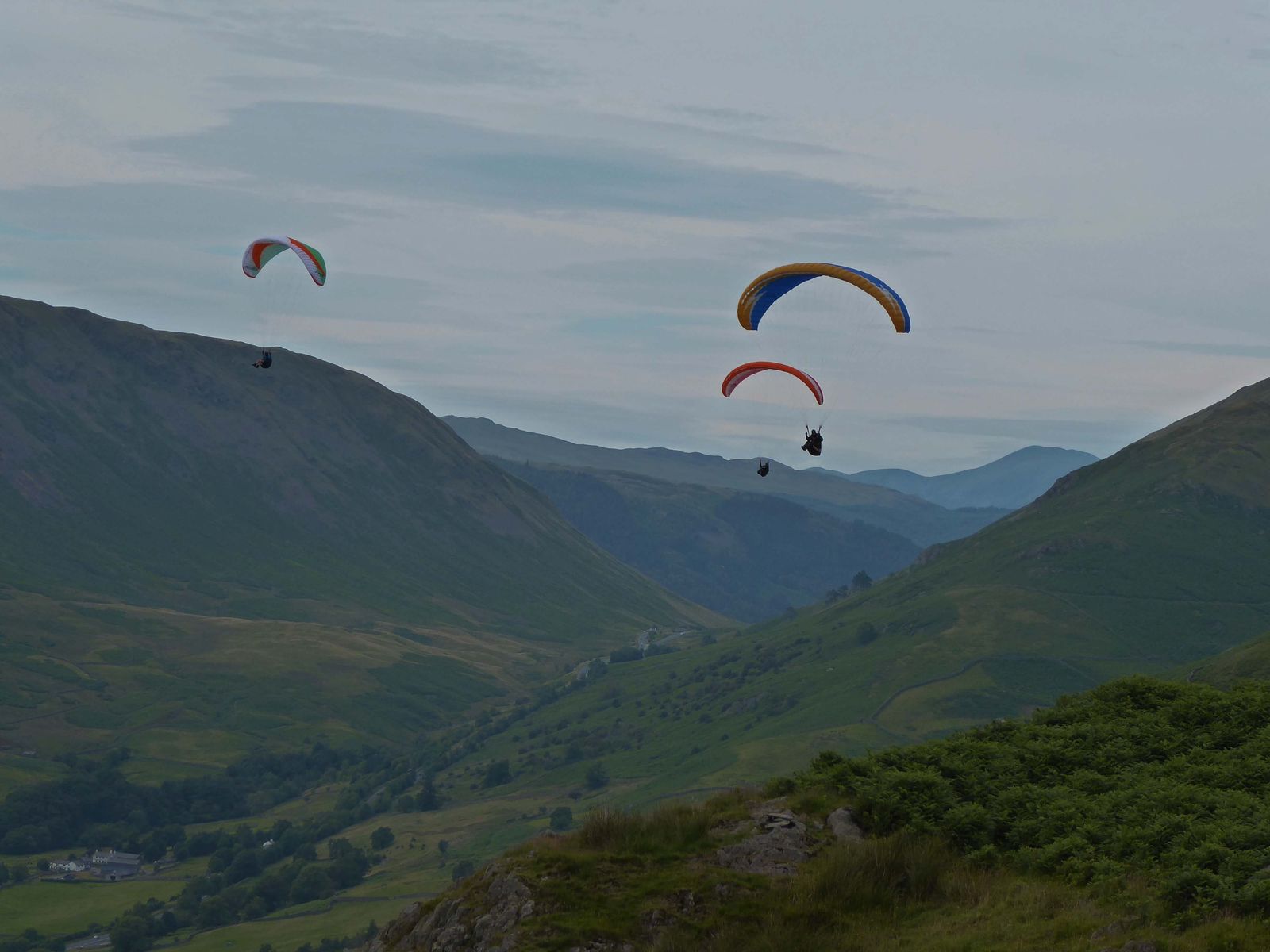Paragliders flying over the fells close to the Grasmere Lakeland Sports and Show showfield.