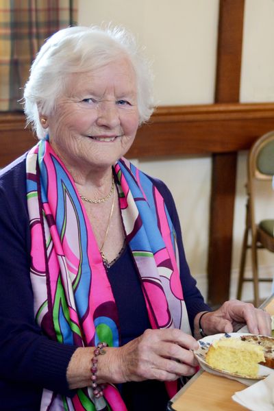 Woman in a scarf eating vegetarian cake