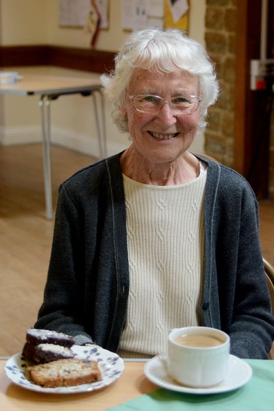 Woman with slices of vegetarian cake and a cup of tea