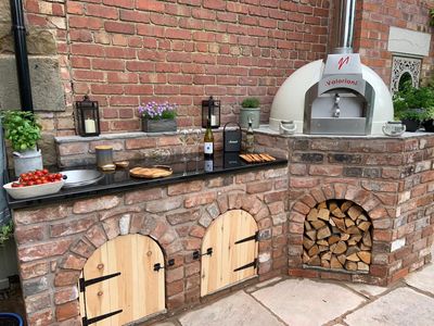 Cream-finish Fornino 75 oven incorporated into an outdoor kitchen design built in brick.