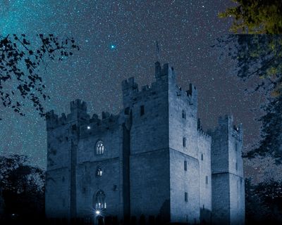 Langley Castle in dark sky, starry night setting