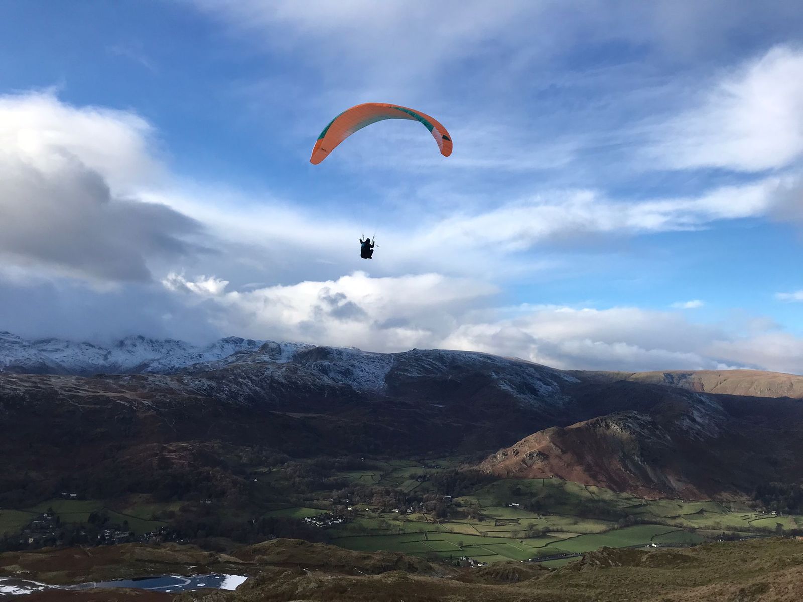 Paragliding in action over the glorious Lake District fells, providing a fabulous view of the landscape.