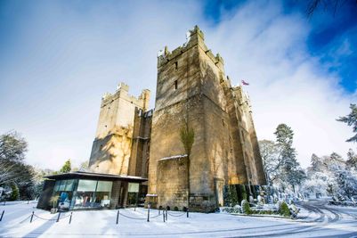 Side view of Langley Castle in the snow, showing the modern Glass Pavilion