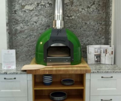 Cucina - the indoor version of the Fornino 60 oven - in an indoor kitchen setting and in a green colourway