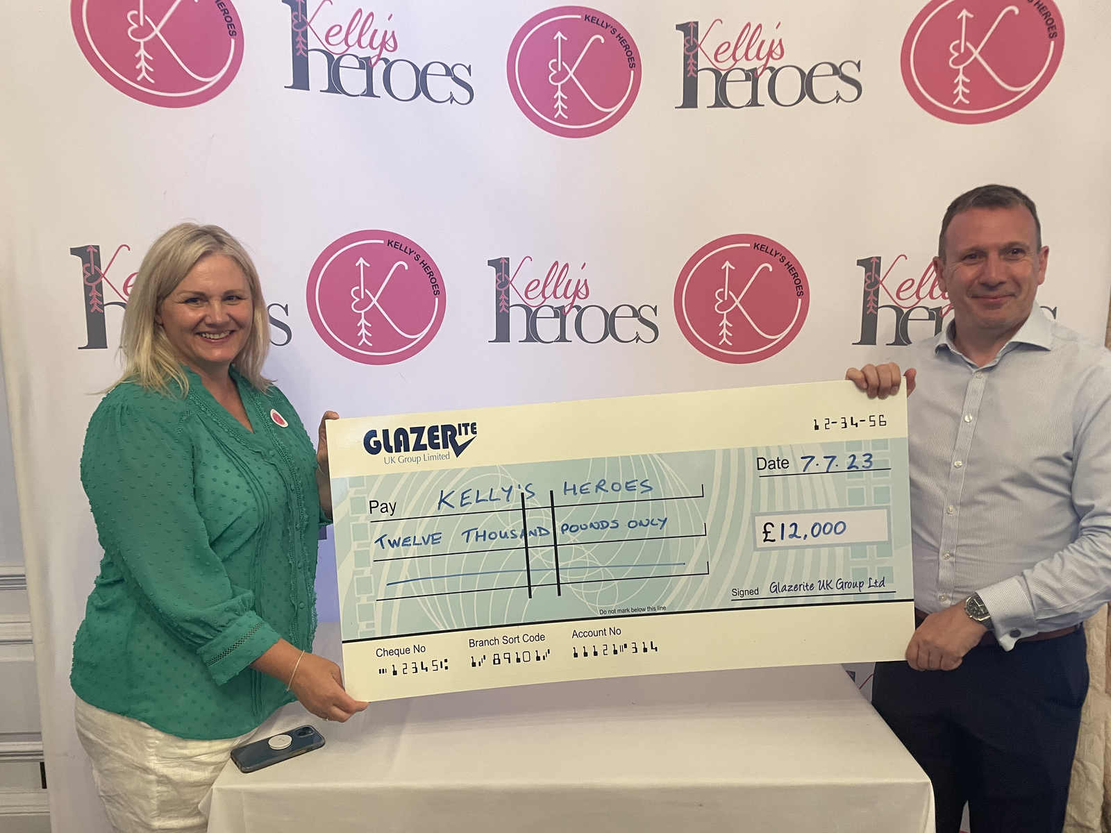 Glazerite's Jeff Dunn presents Sherry Adams, CEO of Kelly's Heroes with the money raised from Glazerite's 17th Pro Am Golf Day