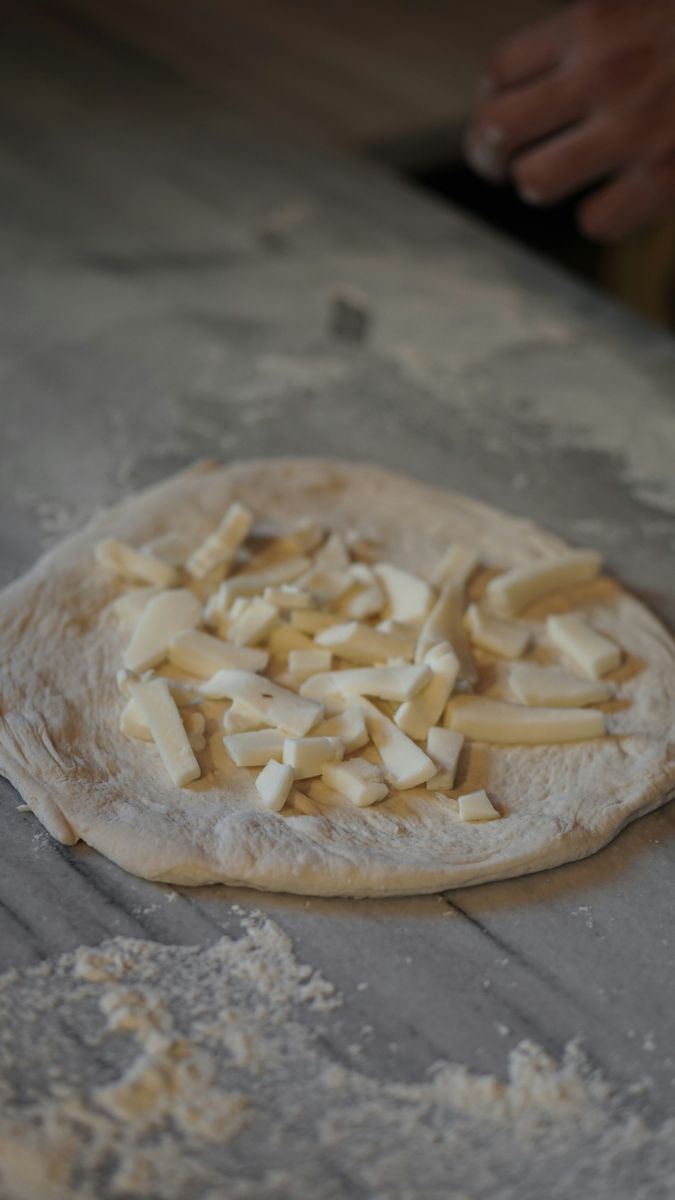 A Neapolitan pizza base and mozzarella ready to be utilised on the top.
