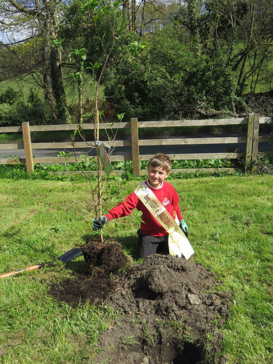 A pupil proudly plants their tree at Langley Castle.
