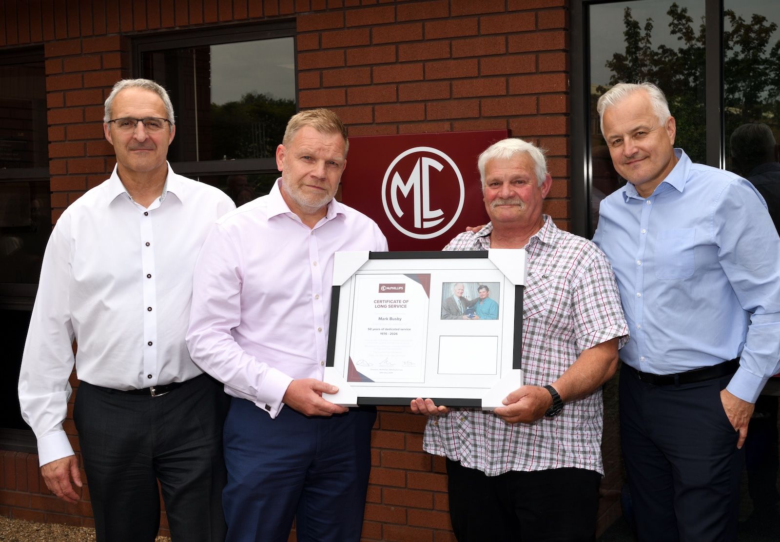 Mark Busby stood with McPhillips directors and presented with a framed certificate.jpg