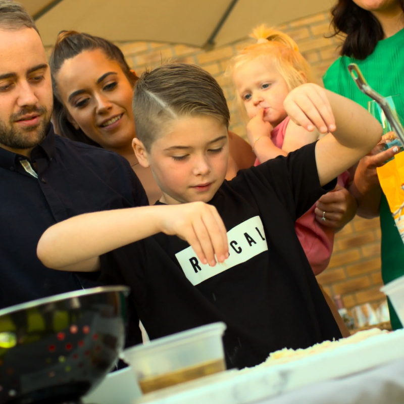 Families bonding over pizza making in a UK garden and with an Orchard Ovens supplied Valoriani pizza oven