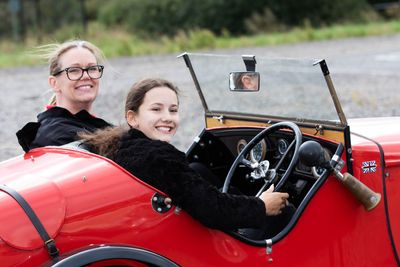 A young person drives Young Driver's Austin 7 under the watchful eye of an instructor