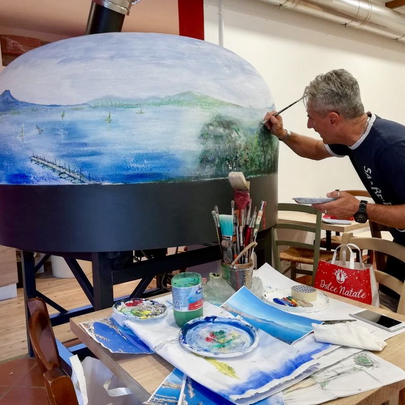 A pizza oven being hand painted with a bespoke design,  in the Valoriani factory in Tuscany